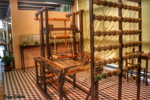 La exposición de "El Telar" enseña a todo visitante que se acerque al Museo Escolar de Pusol cómo se elaboraba la cinta de fibra de cáñamo o de pita en dicha industria, con la que se confeccionaba la pala y el talón del calzado.